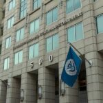 Convicted Killer Faces Deportation After Prison U.S. government building facade with American and blue departmental flags