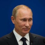 Russia Invites Talks, Ukraine Rejects Moscow Venue A political figure speaking at a press conference against a blue background