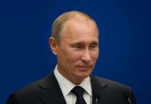 Russia Invites Talks, Ukraine Rejects Moscow Venue A political figure speaking at a press conference against a blue background