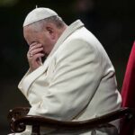 Explosive Claims: Abuse Allegations Against Leading Cardinal Pope sitting with his head bowed and hand covering his face