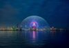 Geodesic dome illuminated at night by the waterfront