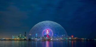 Geodesic dome illuminated at night by the waterfront