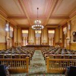 California Lawmakers Reject Ban on Sex Offenders Interior view of a historic courtroom with wooden furnishings and chandeliers