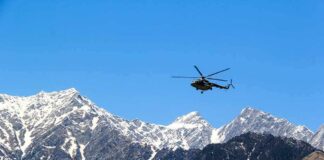 Helicopter flying over snow-capped mountain range