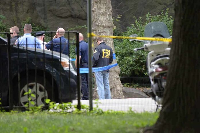 shutterstock_451587268 law enforcement officers gather at taped-off outdoor scene