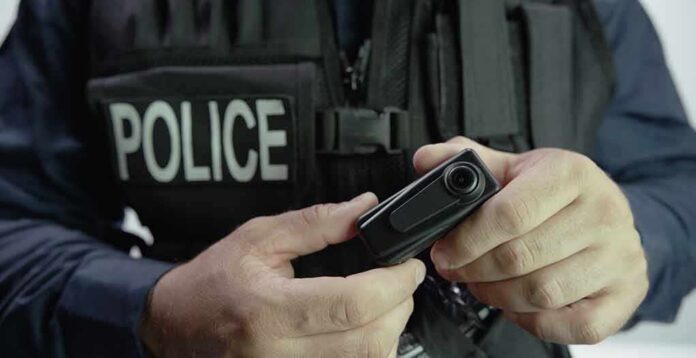 shutterstock_477478378 Police officer holding a body camera