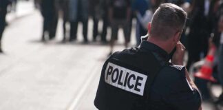 Police officer in uniform communicating with a crowd in an urban setting