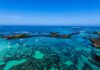 The Viral Dive That Nearly Ended in Tragedy Boats anchored in turquoise lagoon with rocky islets