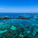 The Viral Dive That Nearly Ended in Tragedy Boats anchored in turquoise lagoon with rocky islets