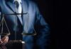 Scales of justice held by a person in a suit