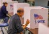 Stolen Identity Fuels 2024 Ballot Shock Man filling out ballot at voting booth