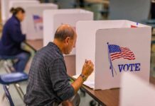 Stolen Identity Fuels 2024 Ballot Shock Man filling out ballot at voting booth