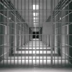 empty prison corridor with barred cells
