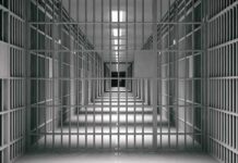 empty prison corridor with barred cells