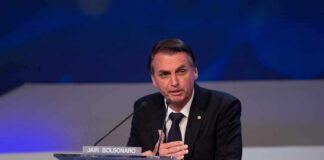 man in suit speaking at a podium