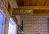 Grand jury sign in a brick-walled hallway
