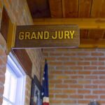Grand jury sign in a brick-walled hallway