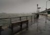 stormy waterfront promenade with benches and choppy water