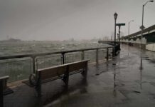 Quick Action Saves Nepali Students From Flood stormy waterfront promenade with benches and choppy water