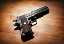 Black handgun on wooden surface