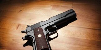 Black handgun on wooden surface