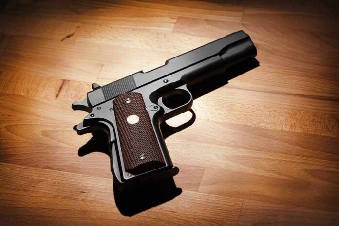shutterstock_125783756 Black handgun on wooden surface