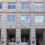 H-1B Visa Fraud Probe Targets Wage Abuse US government building facade with flags and number 500