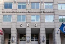 H-1B Visa Fraud Probe Targets Wage Abuse US government building facade with flags and number 500