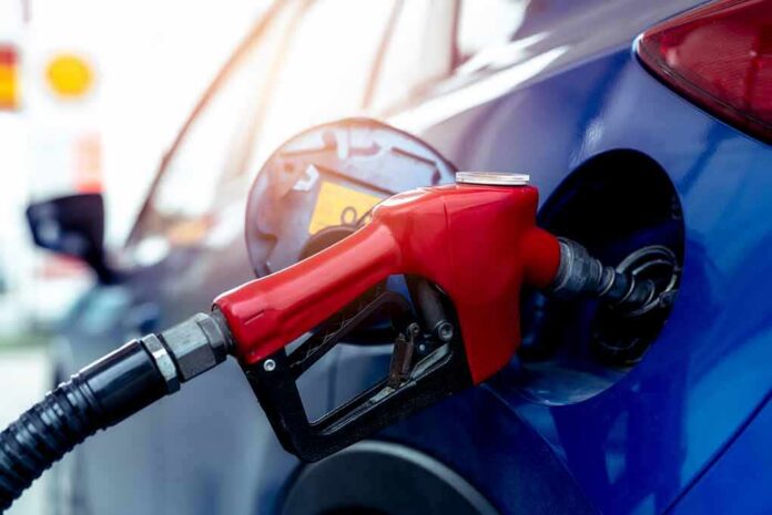 Red gasoline nozzle fueling a blue car
