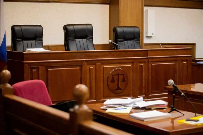 shutterstock_1815414050 empty courtroom with judge's bench and microphones