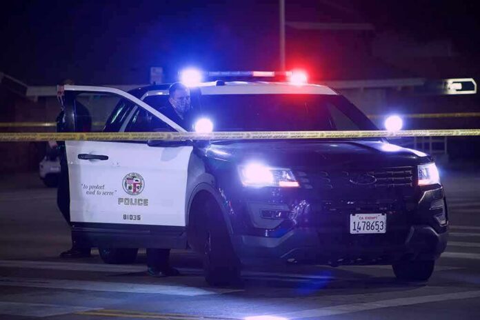 shutterstock_1962160816 Police SUV with flashing lights at night behind yellow tape