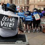 Democrats Warned: Voters May Punish Them Protesters holding signs at a voting rights rally