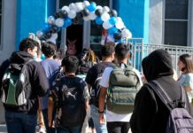 Dual-Enrollment Controversy Explodes Students with backpacks enter a school under a balloon arch