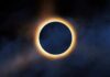 Solar eclipse with bright corona around dark moon