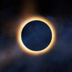 Solar eclipse with bright corona around dark moon