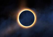 Solar eclipse with bright corona around dark moon
