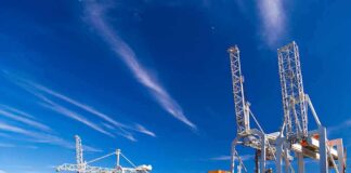 Container ship docked at port with cranes loading cargo