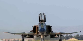 Military jet taxiing on runway with open canopy