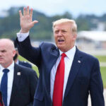Trump’s Ireland Visit Brings Massive Security Operation Donald Trump waves while walking outdoors with security nearby
