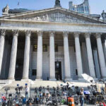 LA Homeless Agency Loses Federal Funding Reporters and photographers gathered outside a neoclassical courthouse