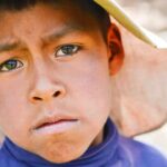 Rare Cancer Spike: Six Kids, One Community boy wearing a wide-brim hat in a close-up portrait