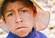 Rare Cancer Spike: Six Kids, One Community boy wearing a wide-brim hat in a close-up portrait