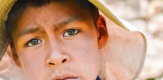 boy wearing a wide-brim hat in a close-up portrait