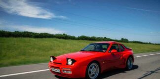 Red sports car driving on a rural highway