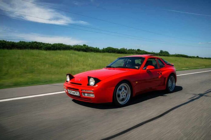 Red sports car driving on a rural highway