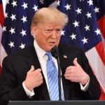 Primetime Clash: Trump Repeats 2020 Fraud Allegations Donald Trump speaking at a podium with American flags behind him
