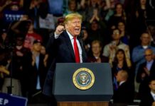 Midterms Teeter: Americans Sour on the Economy Donald Trump speaking at a rally behind a presidential podium