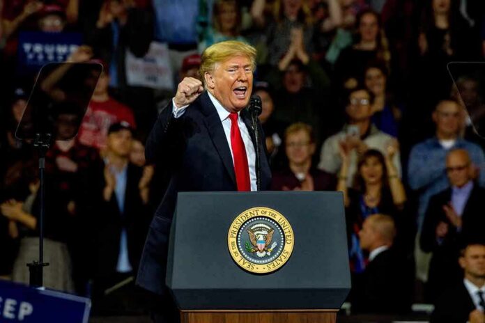 shutterstock_1204270459 Donald Trump speaking at a rally behind a presidential podium