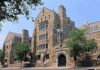Historic university building with stone facade and surrounding trees