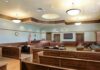 $585K Disability Case Ends in Prison Empty courtroom with wooden benches and judge's bench